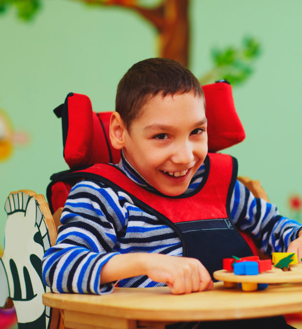 Young boy with special needs sitting on the chair smiling