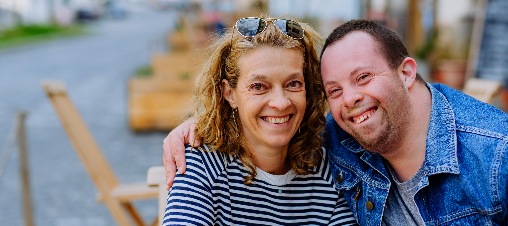 Man with special needs with his mother smiling at the camera