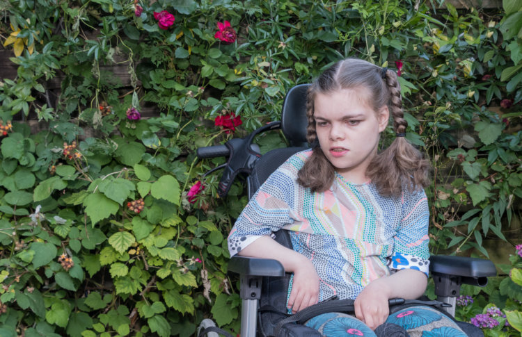 Young girl with special needs sitting in a wheelchair