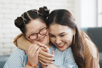 Woman hugging girl with special needs