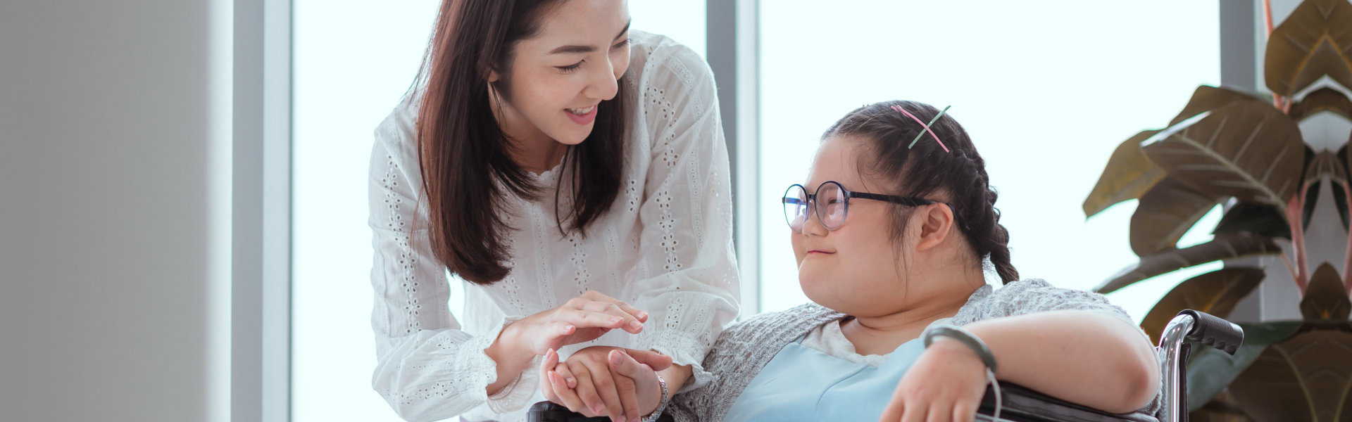 Caregiver monitoring woman with special needs as she paints