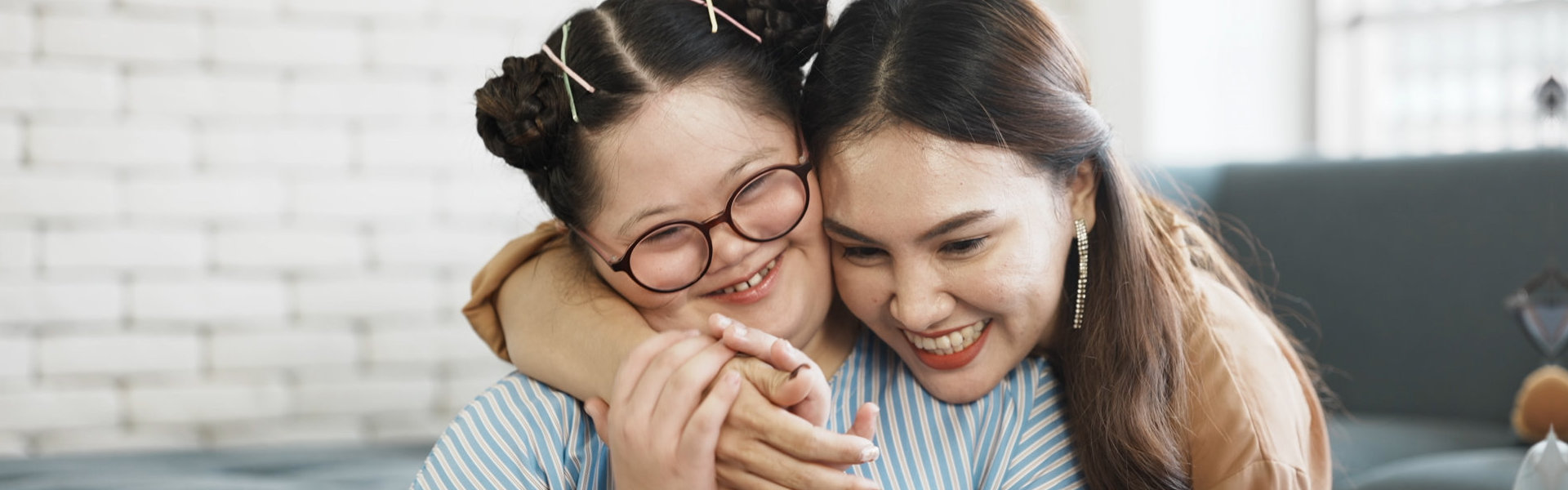 Woman hugging girl with special needs